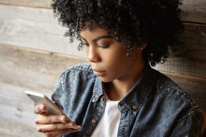 portrait fashionable young dark skinned woman with afro hairstyle having serious look web